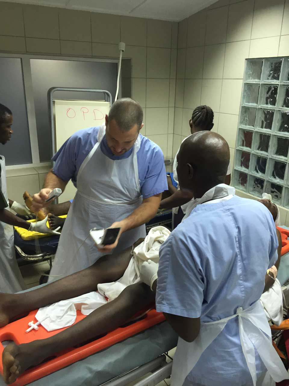 Marco, chirurgo di EMERGENCY in Sierra Leone, al lavoro in pronto soccorso insieme allo staff