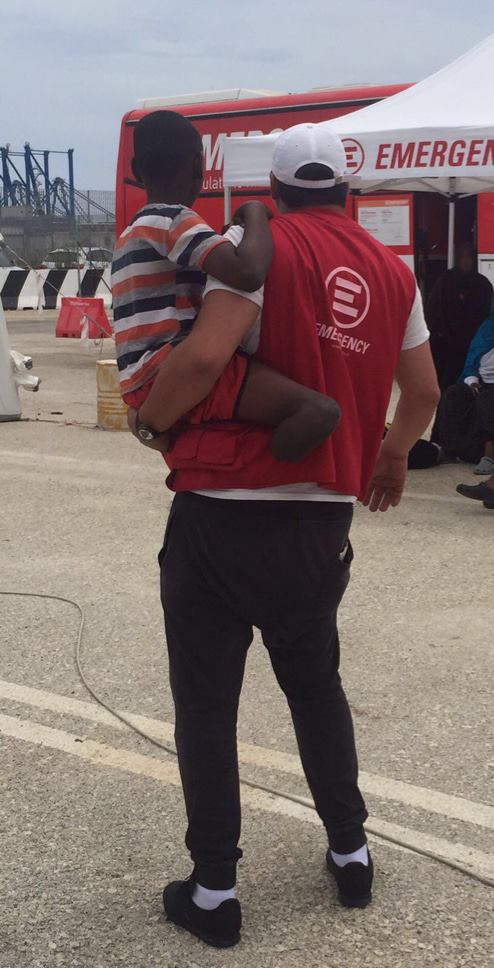 Al porto di Augusta, Bader - mediatore culturale di EMERGENCY - tiene in braccio S., un bambino arrivato dalla Somalia