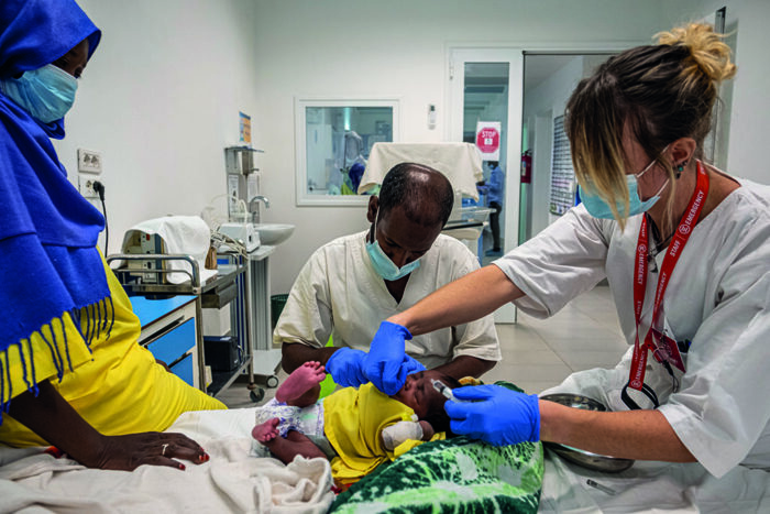 Nurses sooth a baby as a blood sample is being taken during evening rounds in the Port Sudan Paediatric Centre, Sudan.